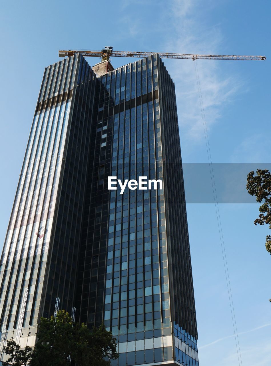 LOW ANGLE VIEW OF MODERN BUILDING AGAINST BLUE SKY