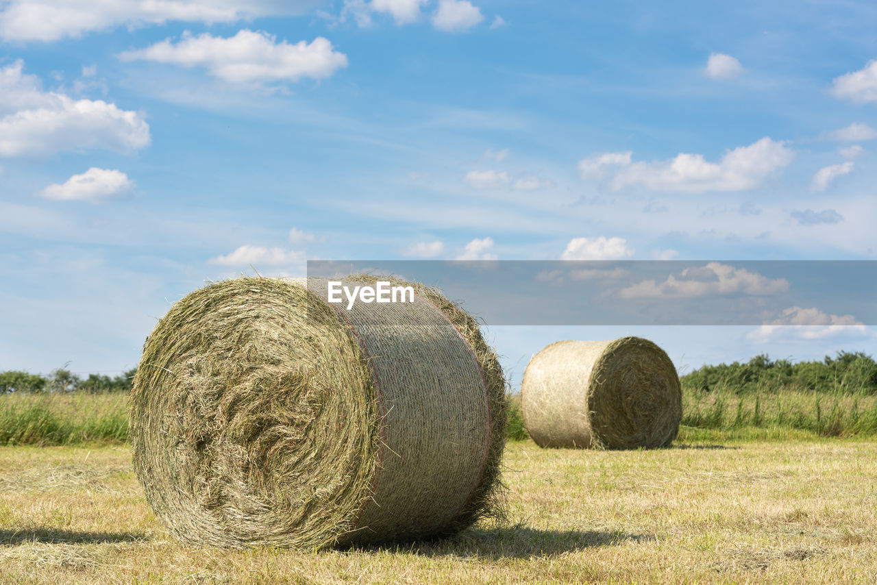 Hay bales on field against sky