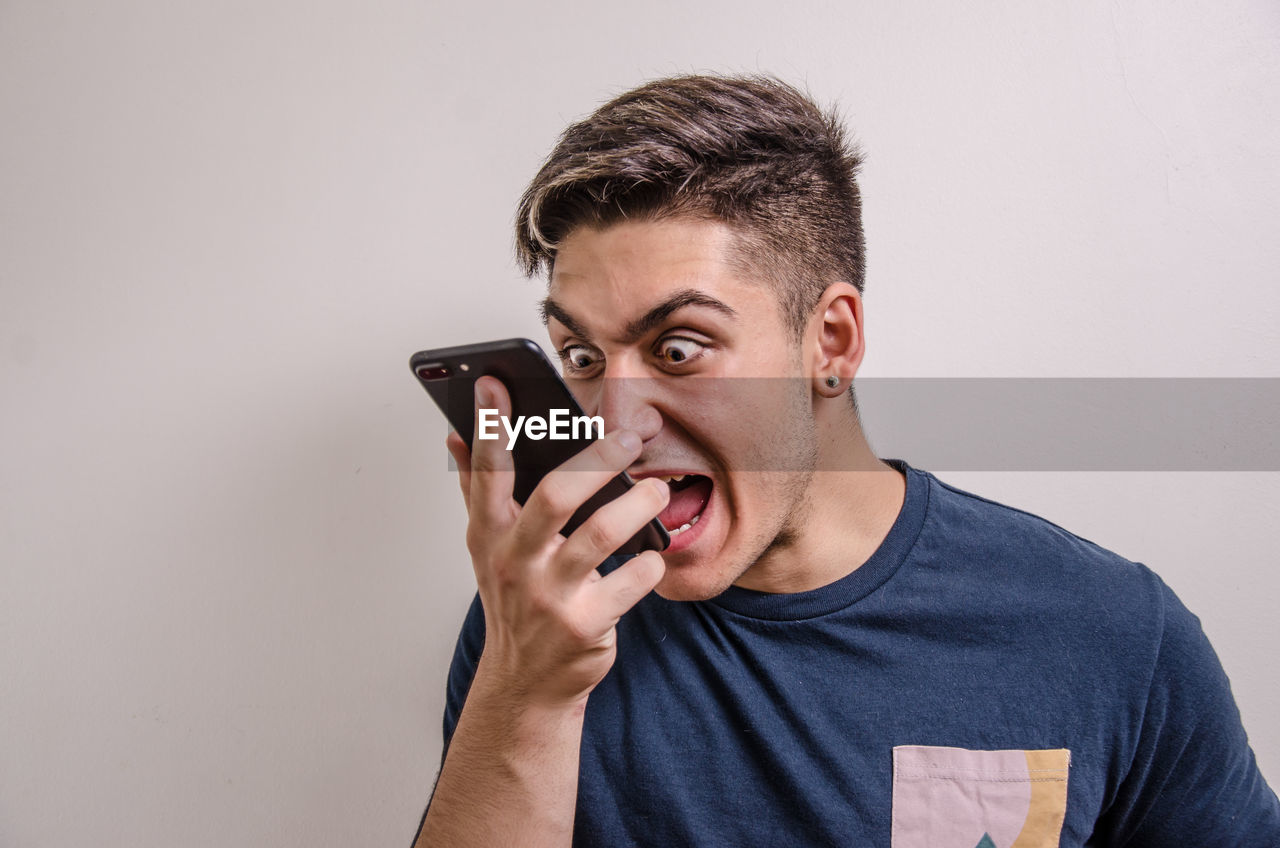YOUNG MAN USING MOBILE PHONE