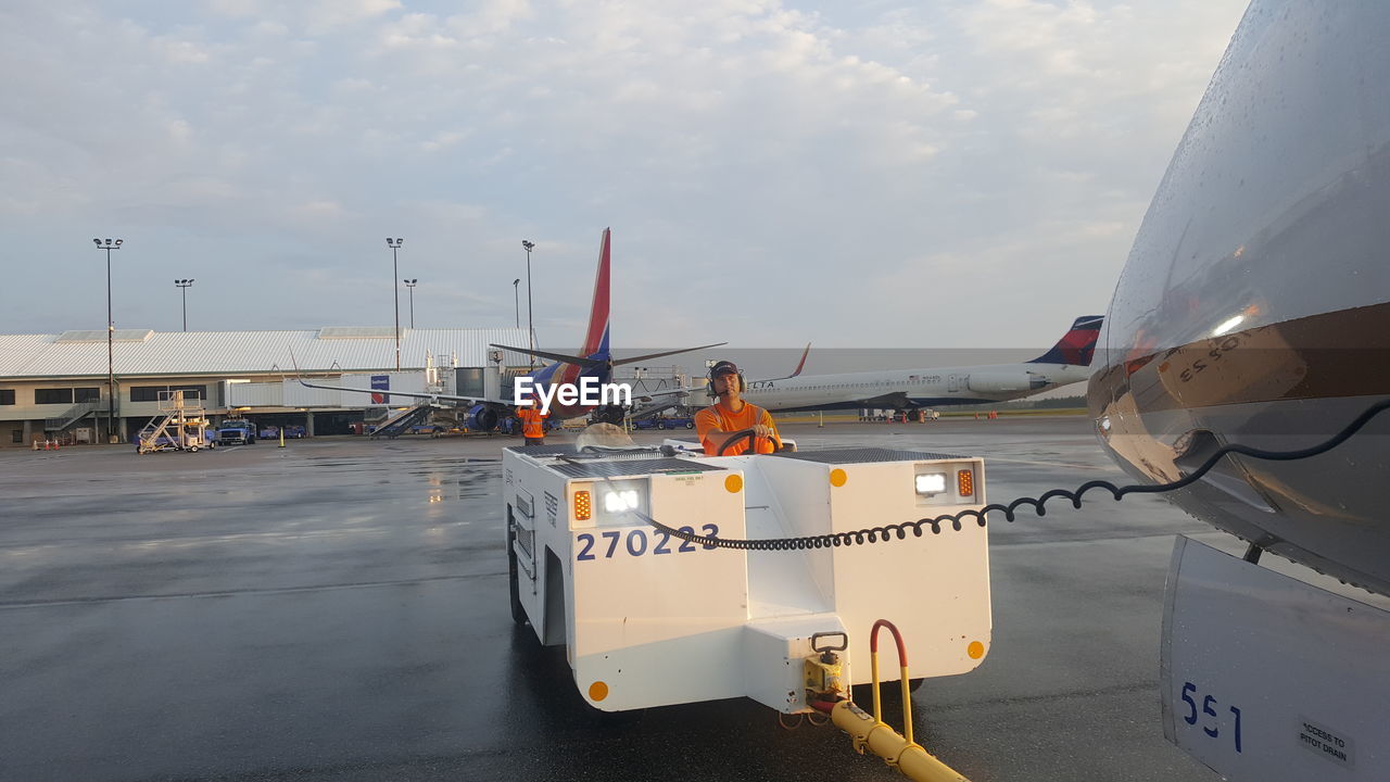 MAN ON AIRPLANE AGAINST SKY