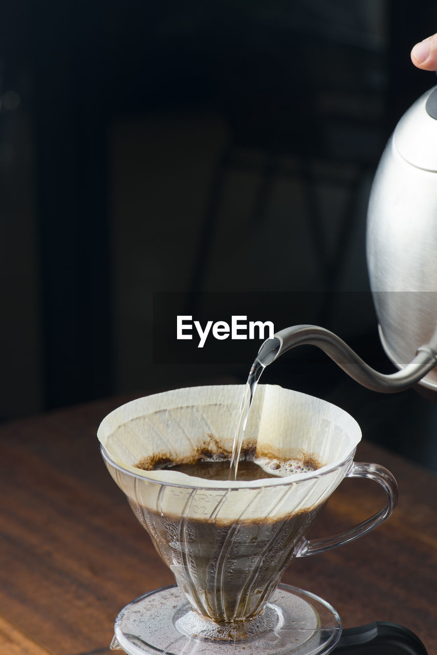 Water pouring in coffee filter on table