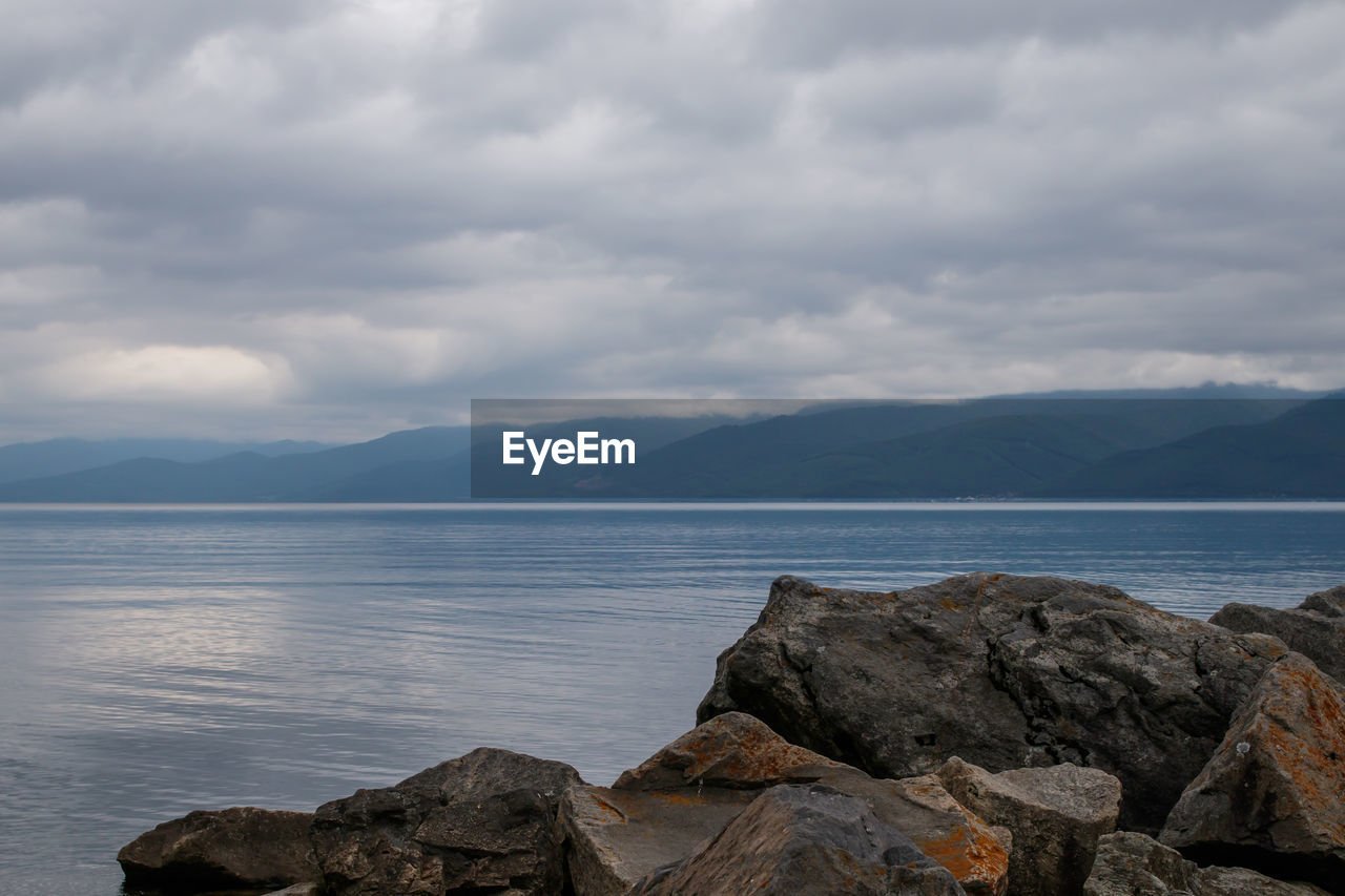  lake baikal in cloudy weather, irkutsk region, russia. in the foreground are large stones.