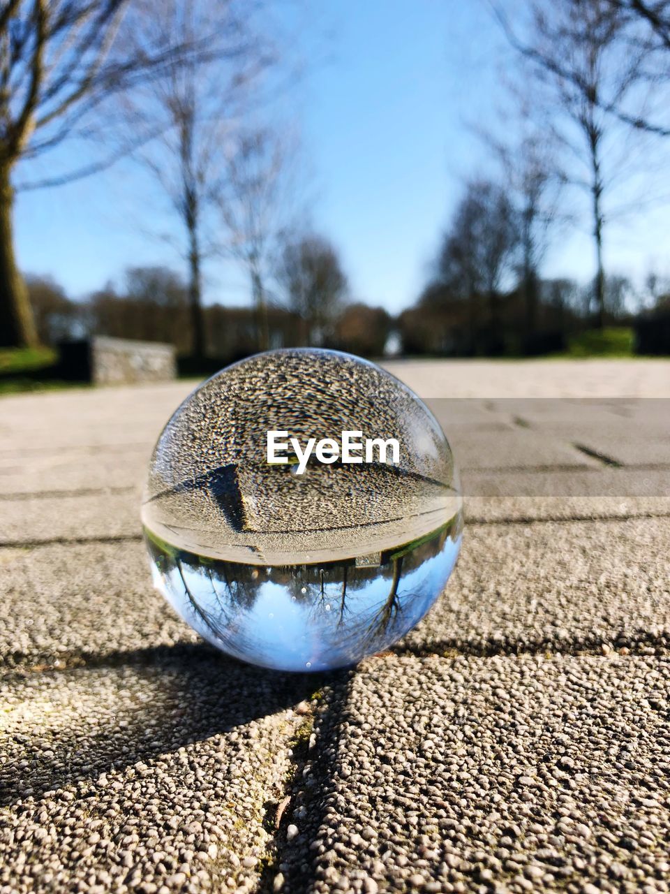 CLOSE-UP OF CRYSTAL BALL ON GLASS AGAINST STREET