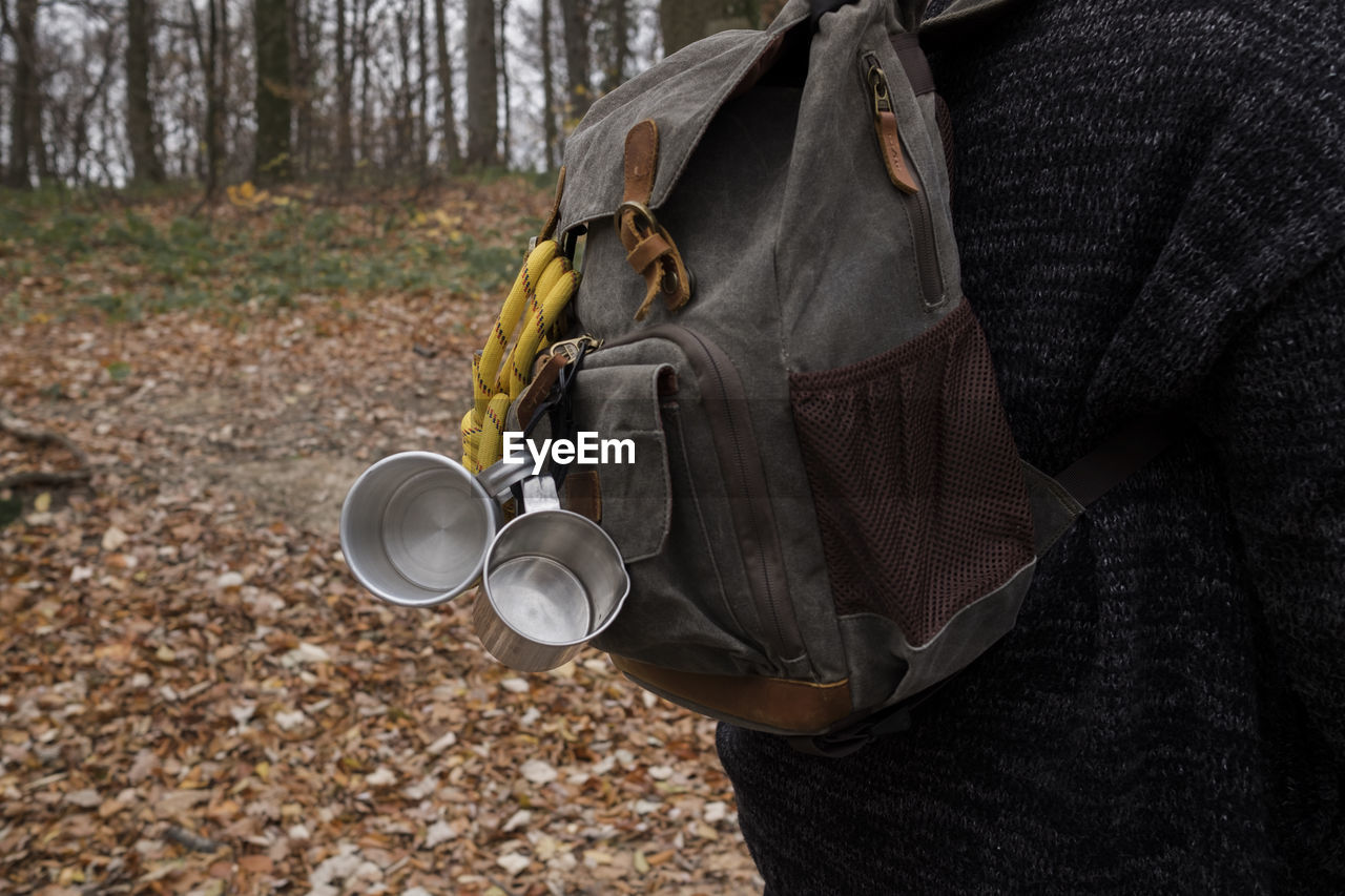 Rear view of person wearing backpack standing in forest