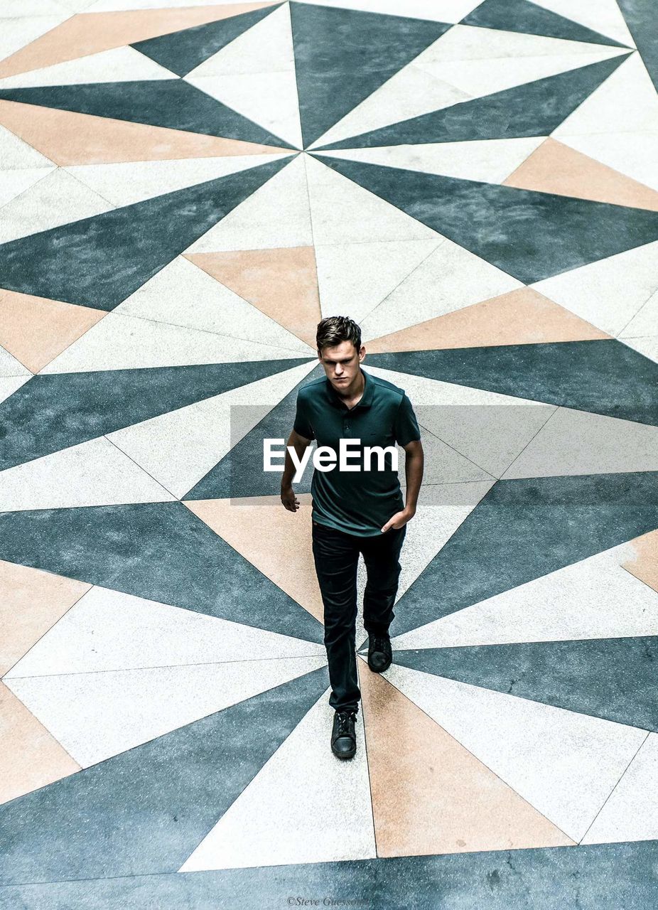 High angle view of young man walking on street