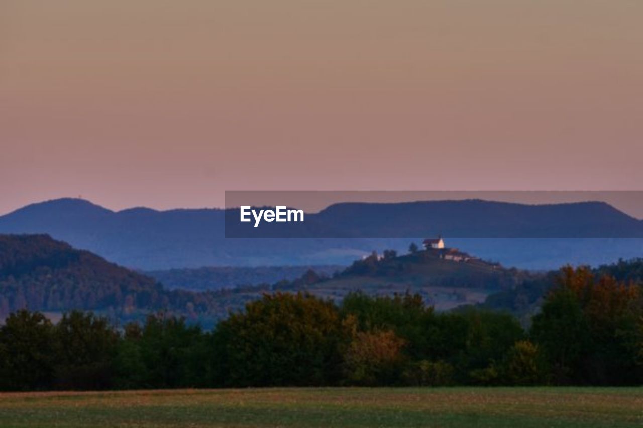 SCENIC VIEW OF MOUNTAINS AGAINST SKY AT SUNSET