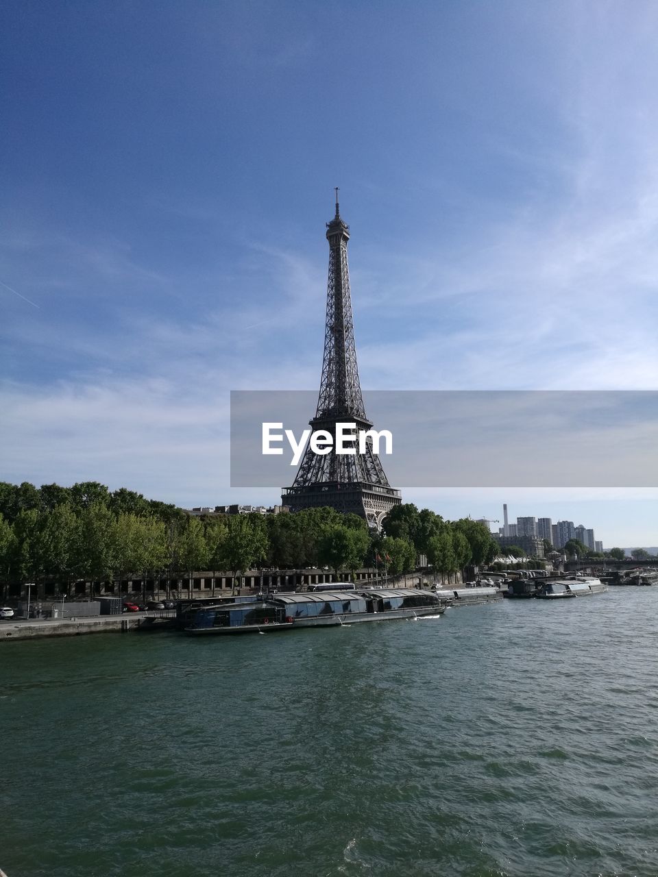 Eiffel tower by seine river against sky