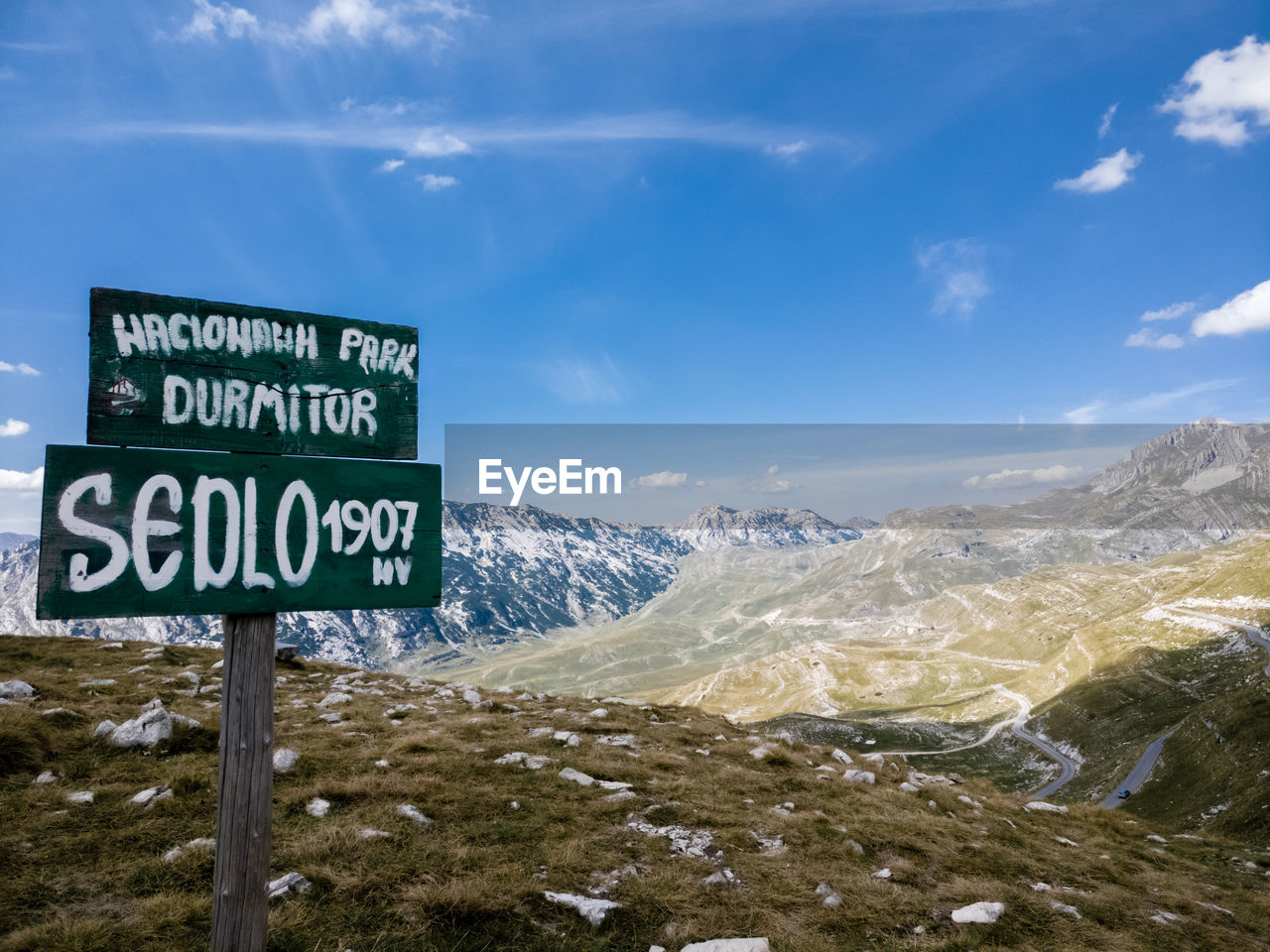 WARNING SIGN ON SNOWCAPPED MOUNTAIN AGAINST SKY