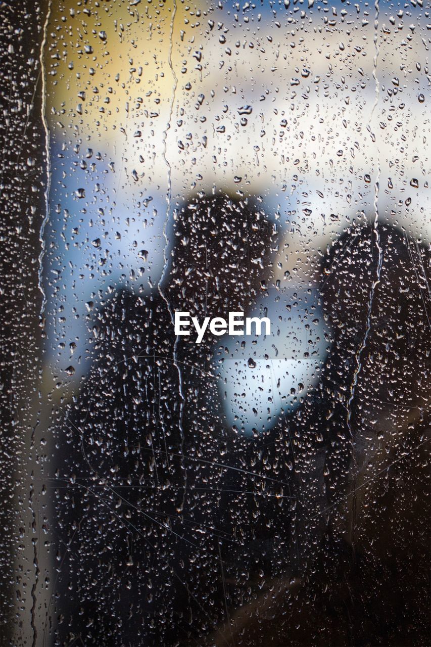 Full frame shot of raindrops on glass window in rainy season