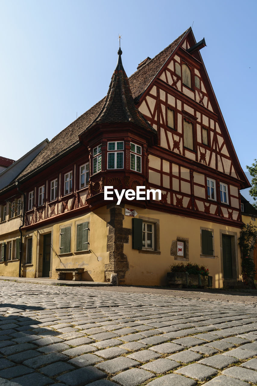 LOW ANGLE VIEW OF OLD BUILDING BY STREET AGAINST SKY