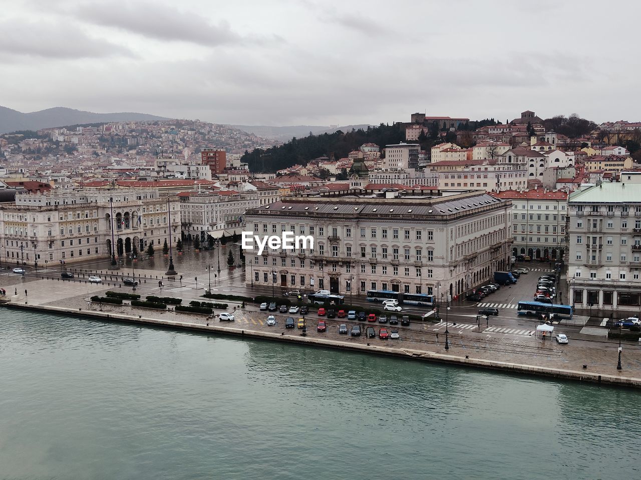 Buildings by river against sky