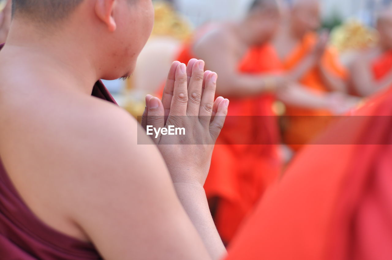 Midsection of monks praying in temple