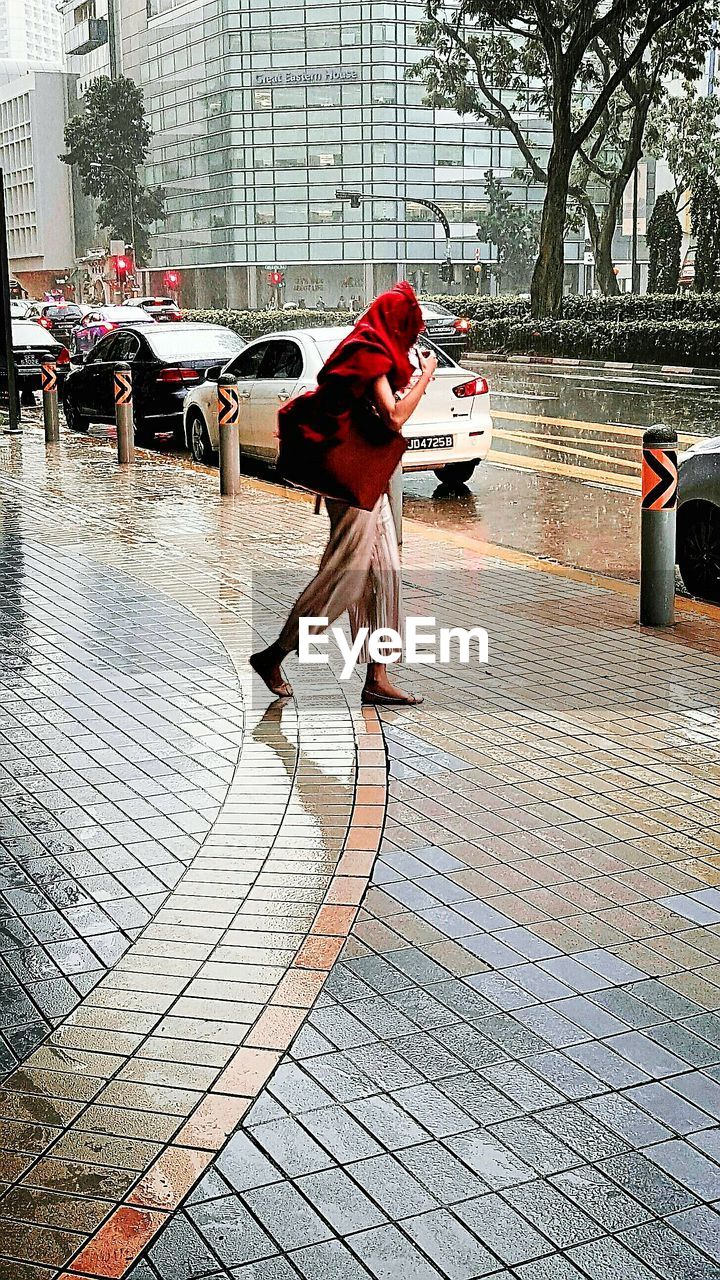 FULL LENGTH OF MAN ON WET UMBRELLA