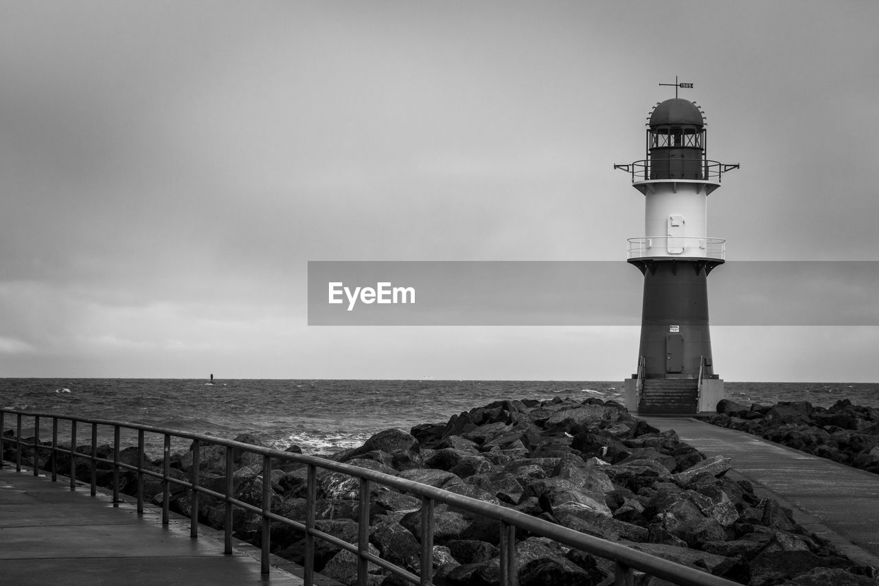 lighthouse, guidance, architecture, sea, water, built structure, tower, sky, security, protection, building exterior, beach, black and white, building, coast, nature, monochrome, monochrome photography, horizon, horizon over water, land, ocean, cloud, travel destinations, no people, coastline, travel, scenics - nature, outdoors, pier, day, observation tower, beauty in nature, tourism, tranquility, water's edge, wave, history, railing, environment