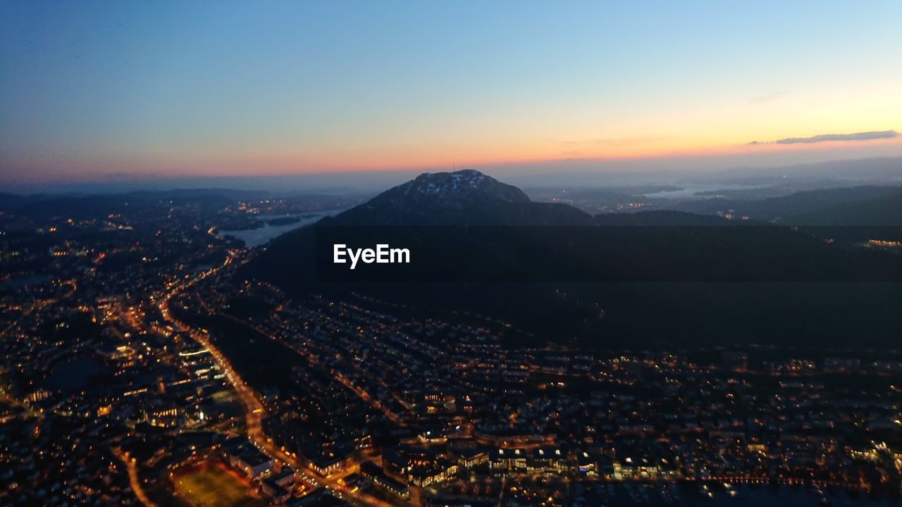 HIGH ANGLE VIEW OF ILLUMINATED CITY AT NIGHT