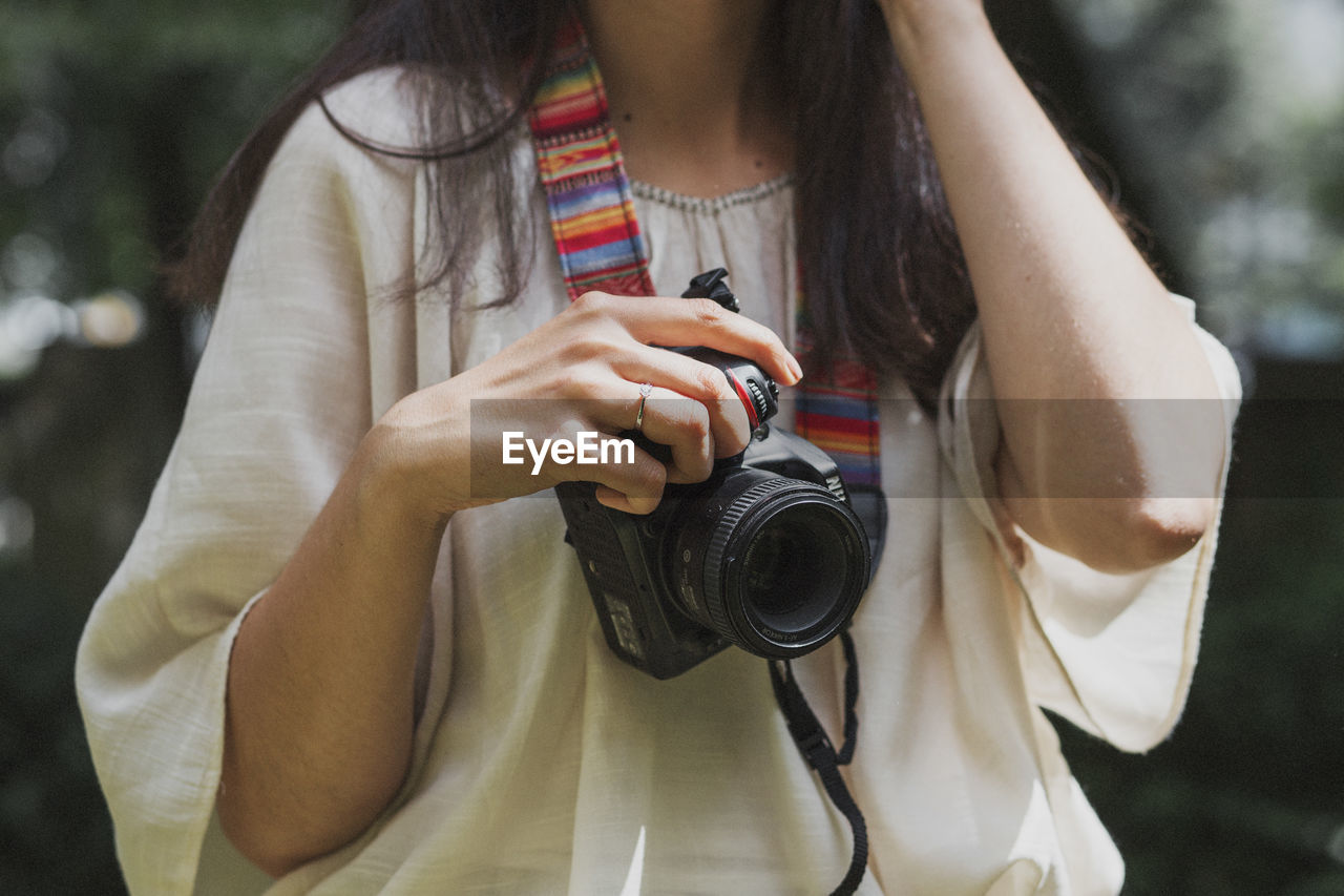 Detail of woman holding camera