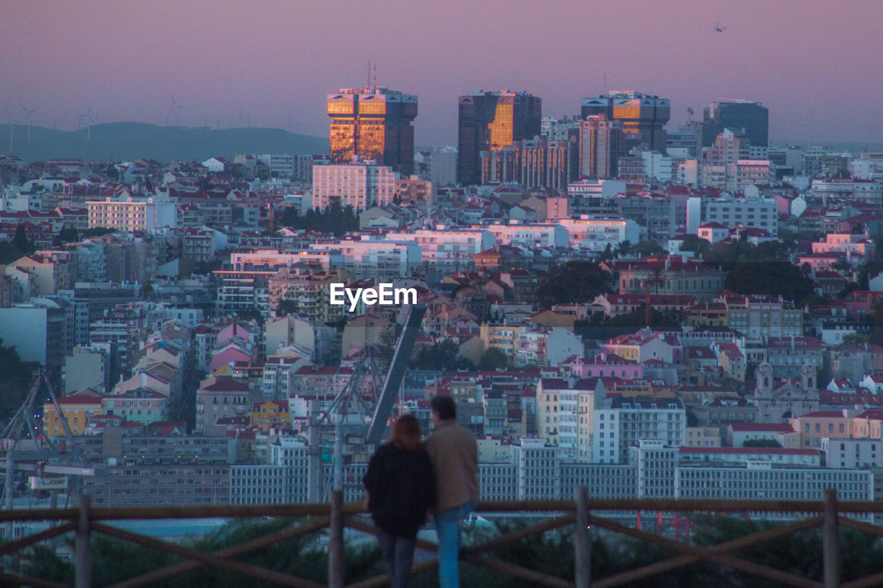 Buildings in city against sky at dusk