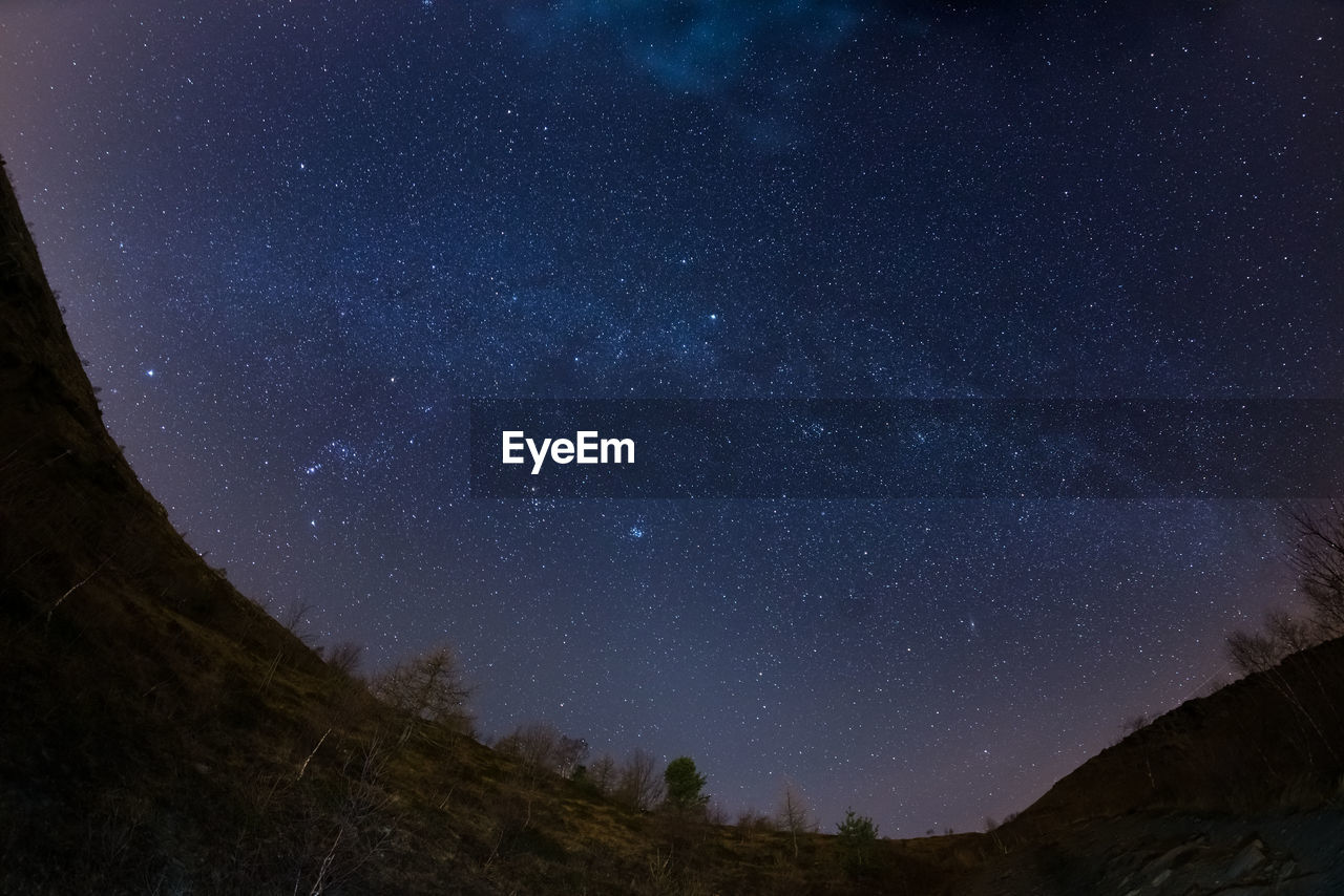 Low angle view of mountains against sky at night