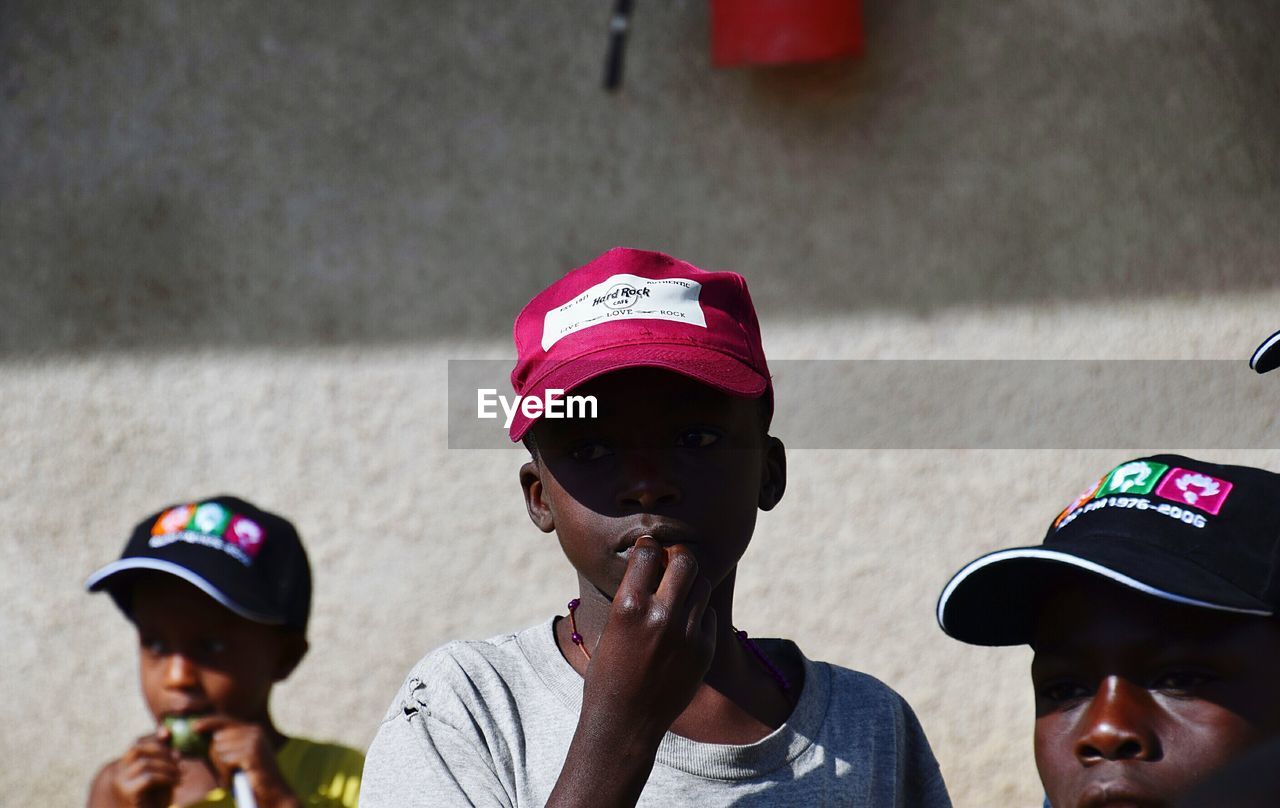 PORTRAIT OF BOY WEARING HAT WITH CAMERA