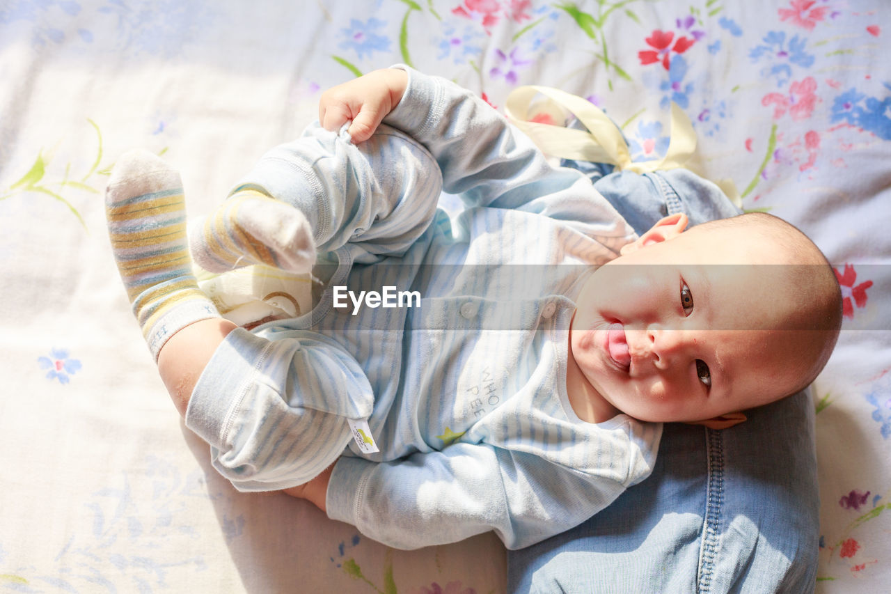 Portrait of baby girl lying on bed