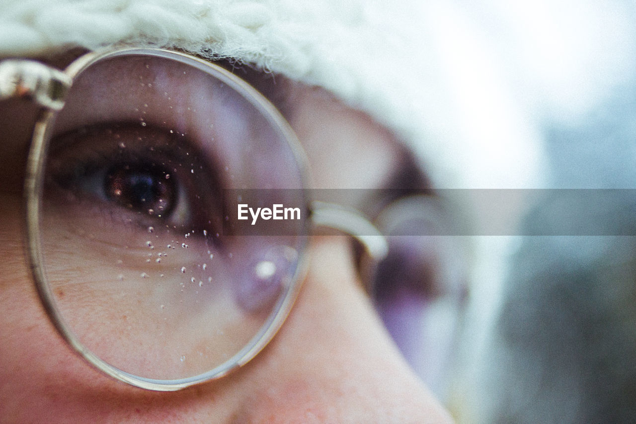 Extreme close-up of woman wearing eyeglasses while looking away outdoors