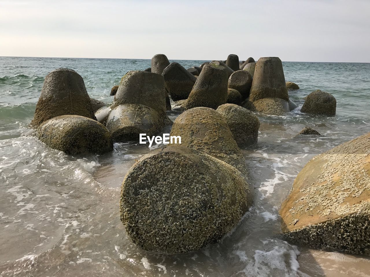 ROCKS ON SHORE AGAINST SKY