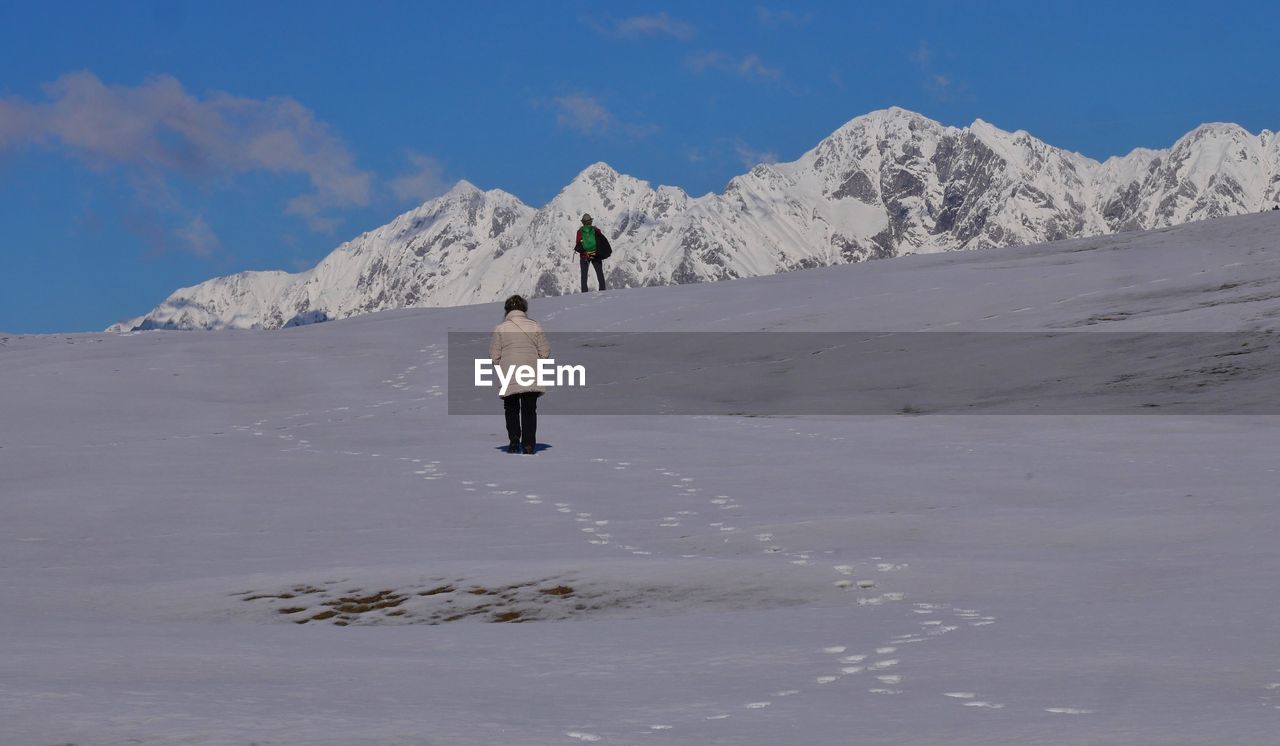 rear view of man skiing on snow covered mountain