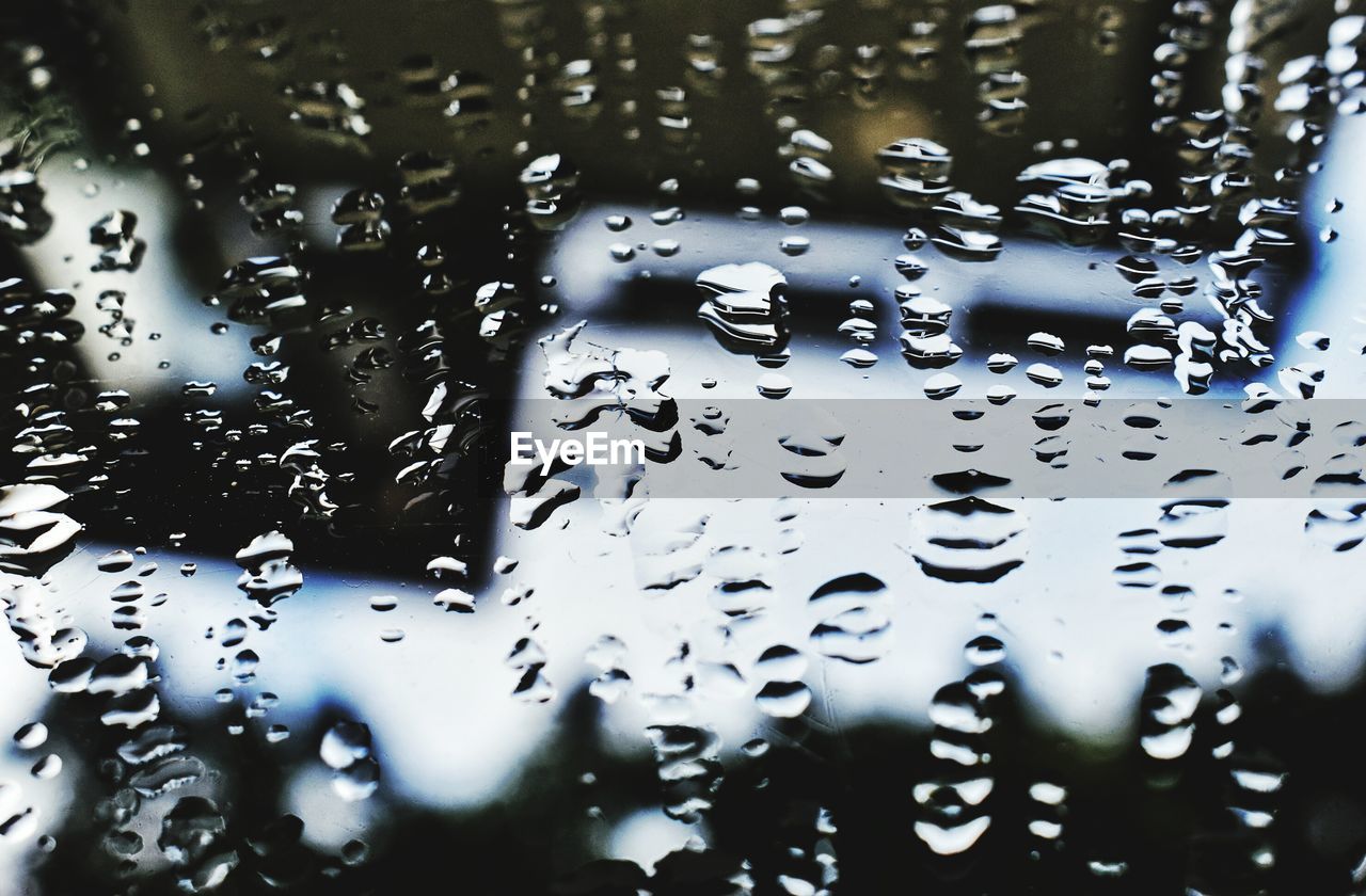 FULL FRAME SHOT OF WET CAR WINDOW IN RAINY SEASON