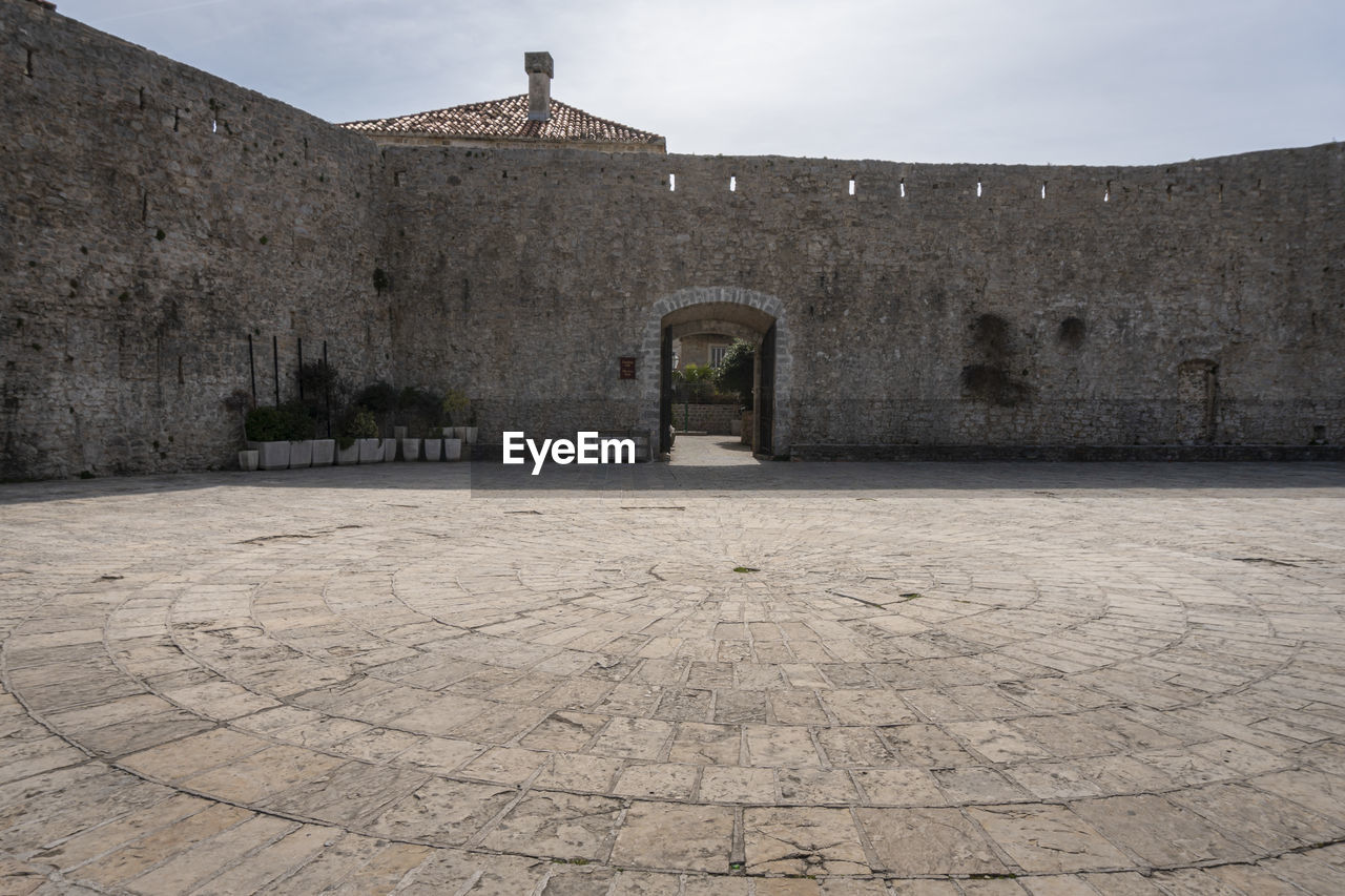 architecture, history, built structure, the past, ancient history, building exterior, sky, building, fortification, travel destinations, nature, cobblestone, no people, city, street, wall, stone material, travel, religion, outdoors, tourism, ancient, old, day, fort, ruins, wall - building feature