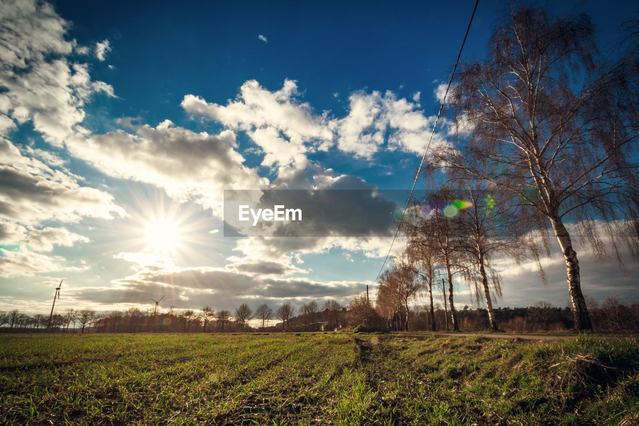 Scenic view of grassy field against cloudy sky