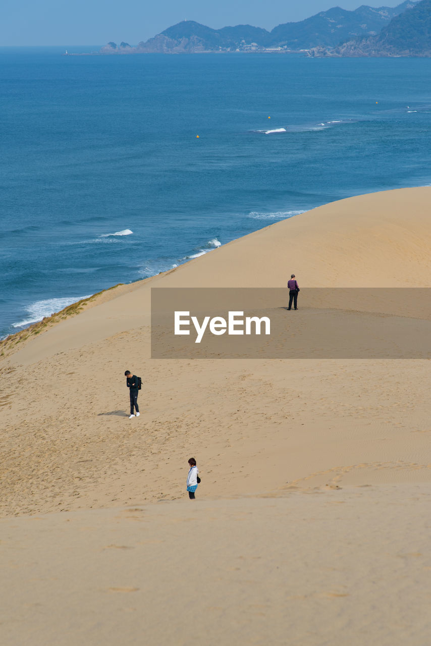 People on beach against clear sky