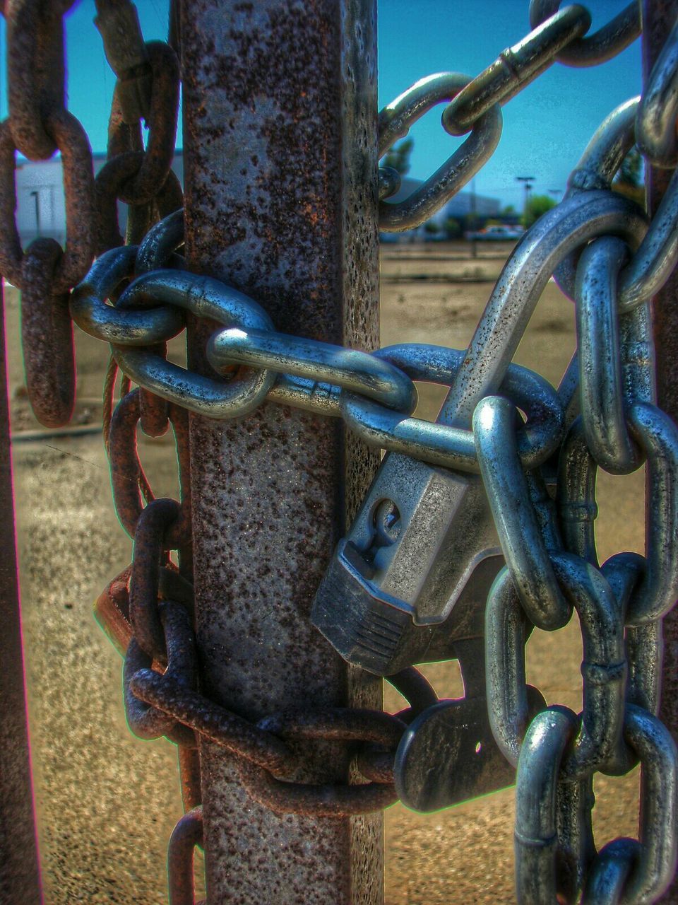 CLOSE-UP OF RUSTY CHAIN ON METAL