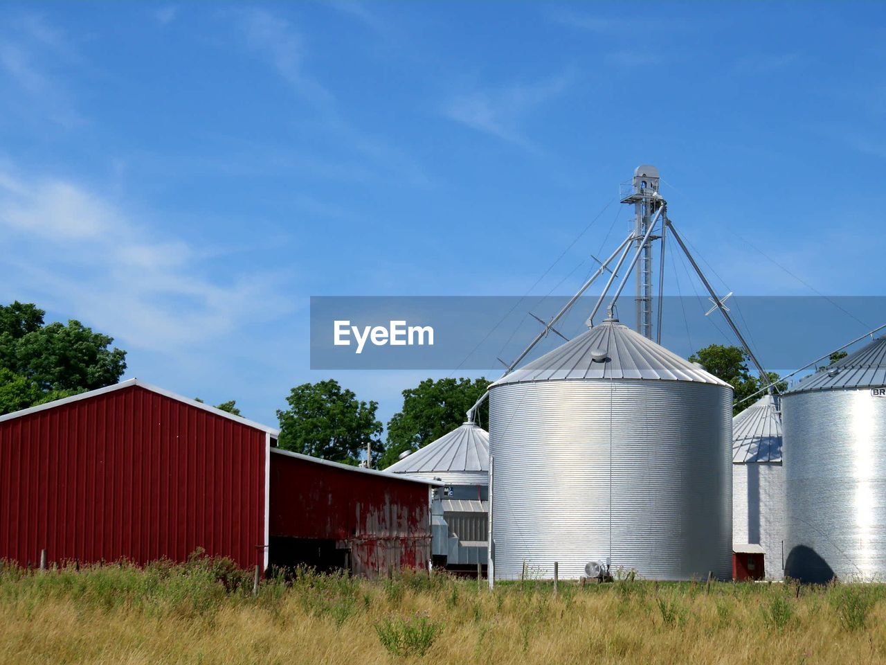 Silos and barn against sky