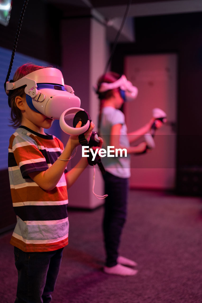 Vr game and virtual reality. team kids friends gamers fun playing on futuristic video game