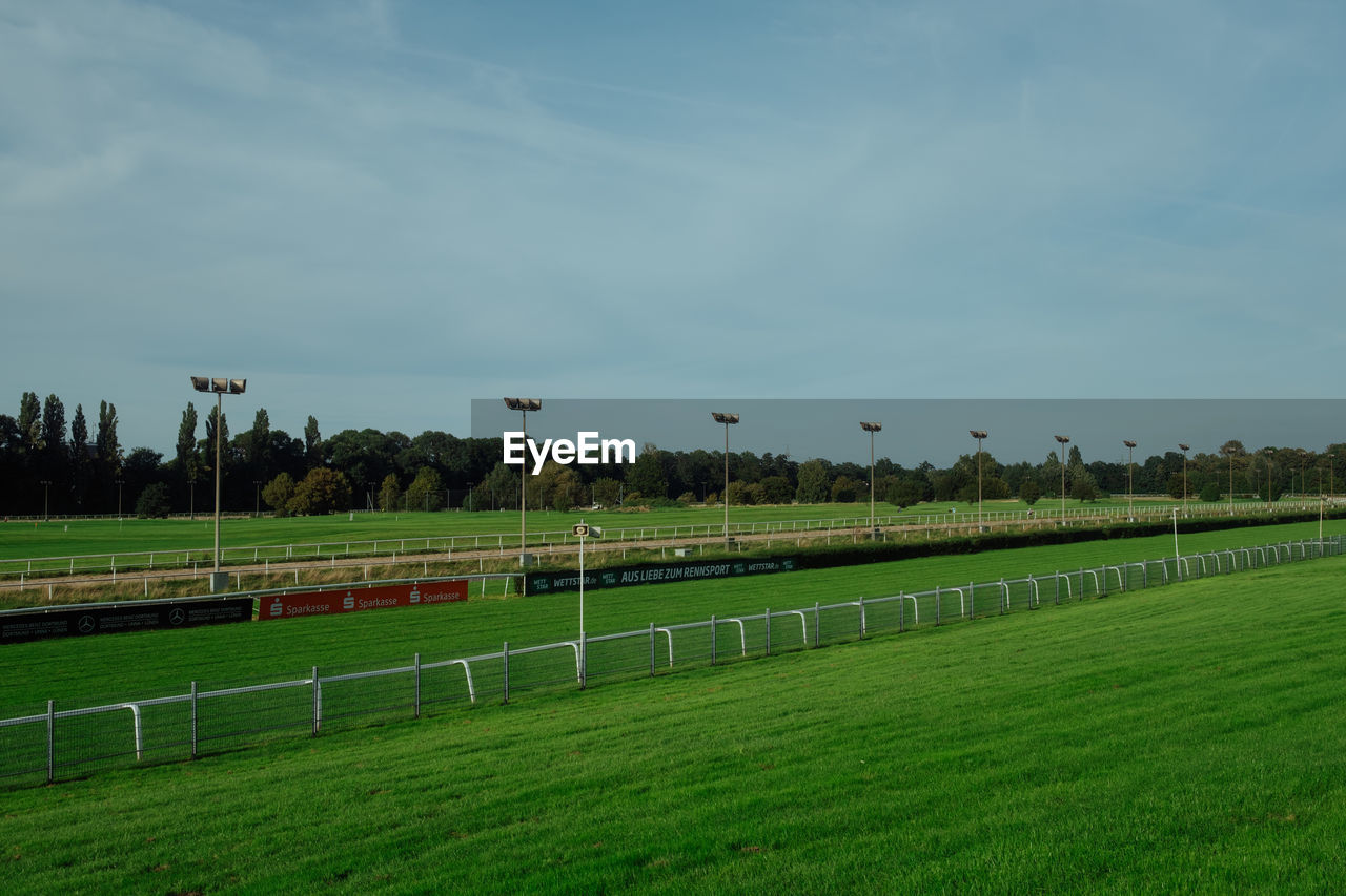 grass, field, sky, plant, agriculture, green, nature, rural area, sports, land, pasture, lawn, horizon, environment, farm, tree, landscape, cloud, no people, plain, sport venue, hill, race track, stadium, grassland, day, outdoors, tranquility, beauty in nature, tranquil scene, soccer, team sport, playing field