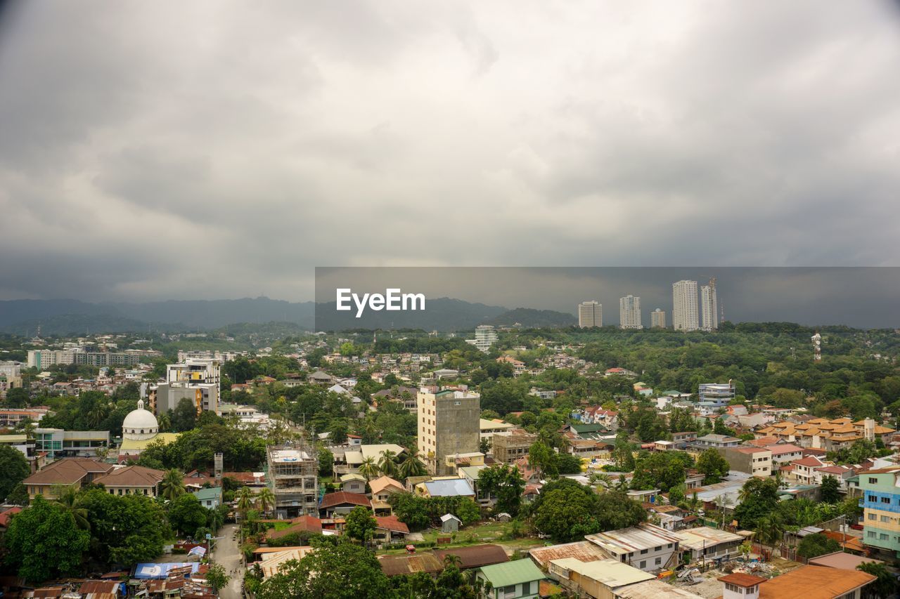 Aerial view of buildings in city against sky