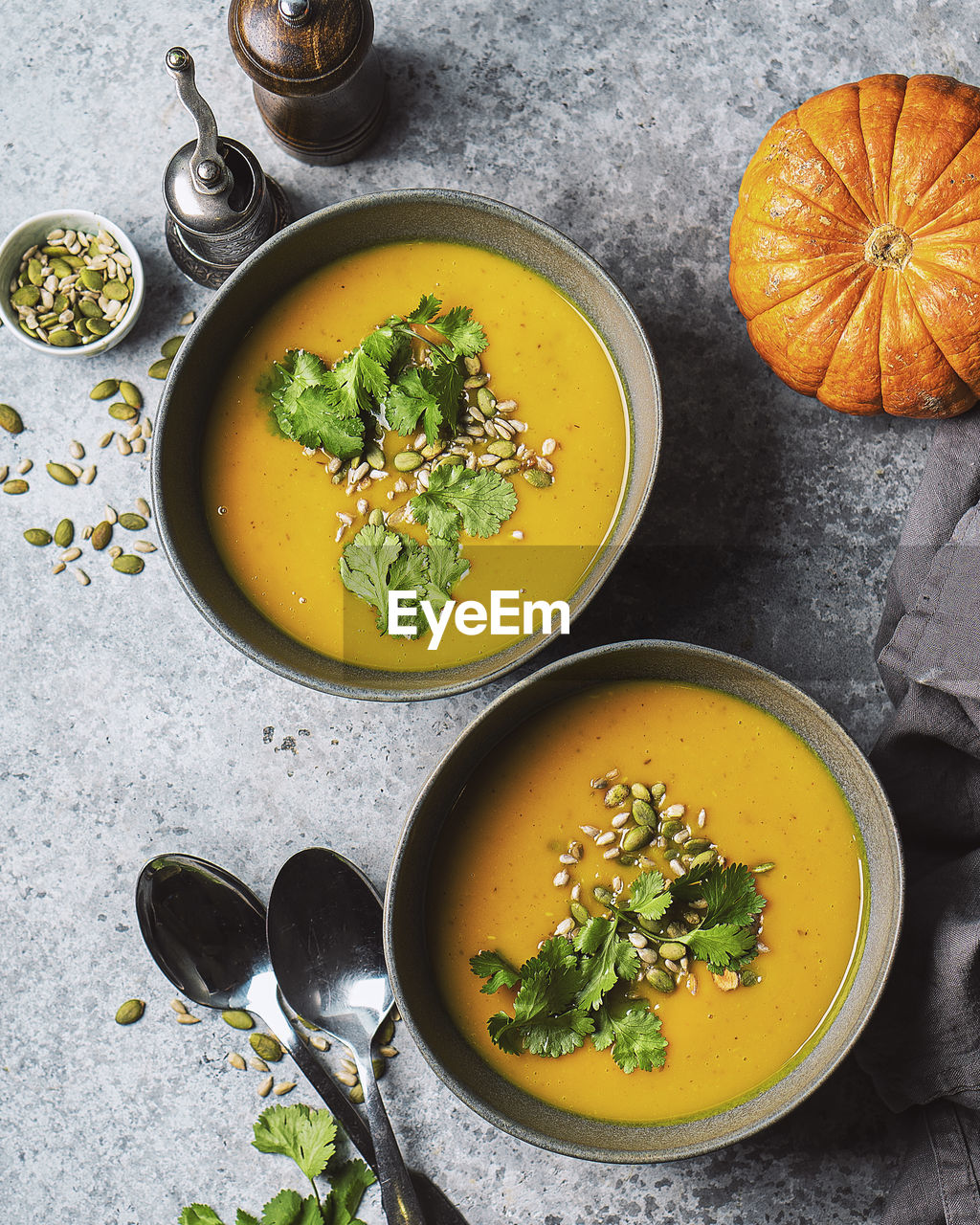 Two bowls of pumpkin soup, top view 