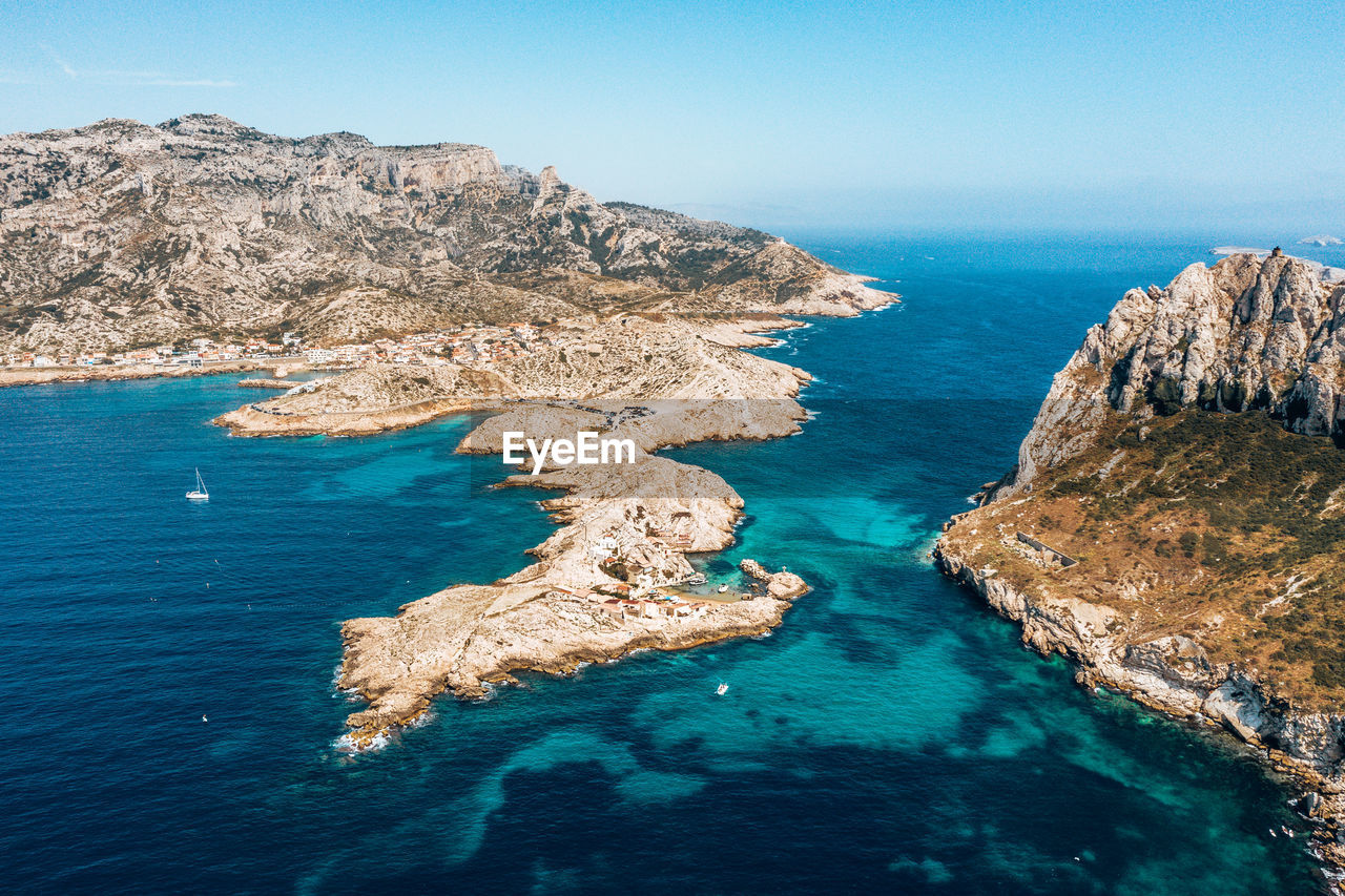 Rock formations in sea against blue sky