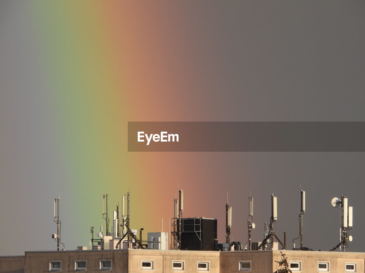 Building roof against sky with rainbow