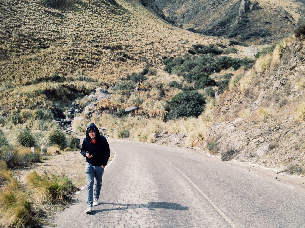 REAR VIEW OF WOMAN WALKING ON ROAD