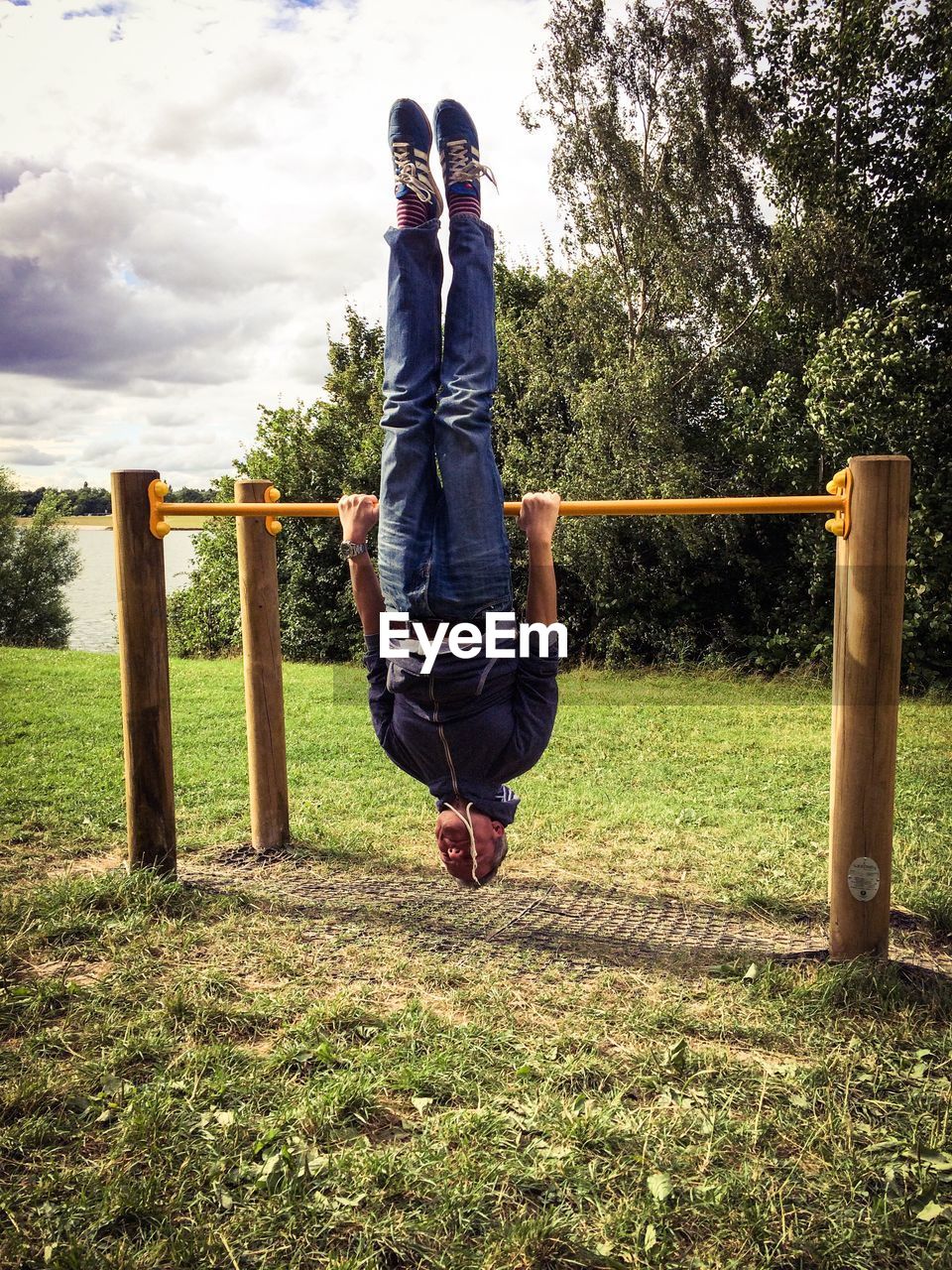 Man hanging upside down over parallel bars