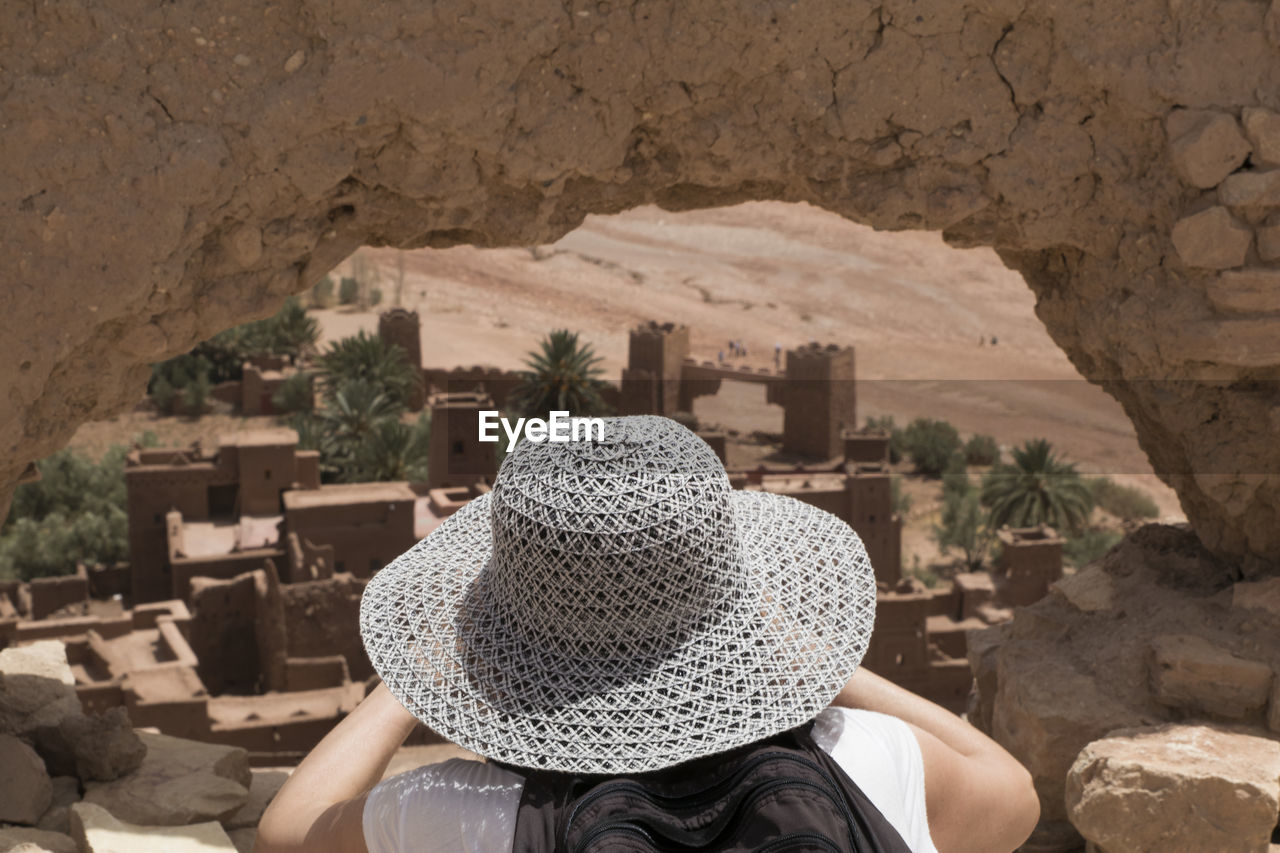 Woman in straw hat on rock