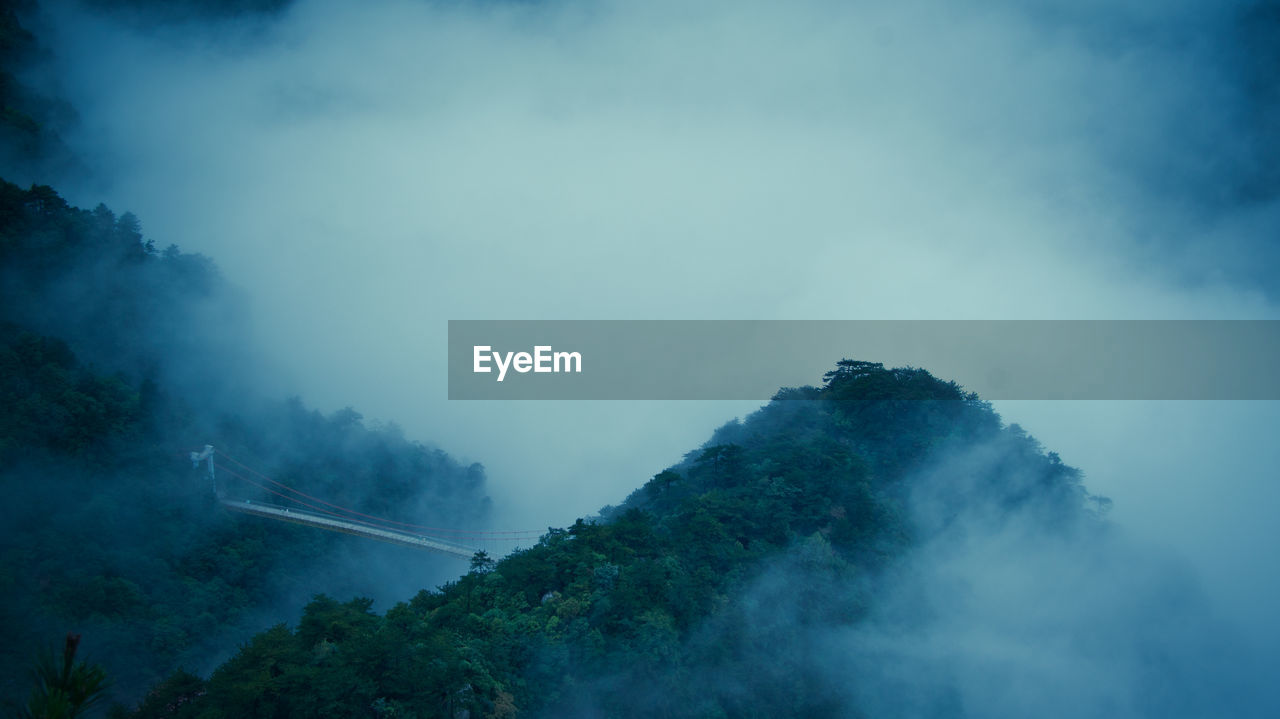 Scenic view of mountains against cloudy sky