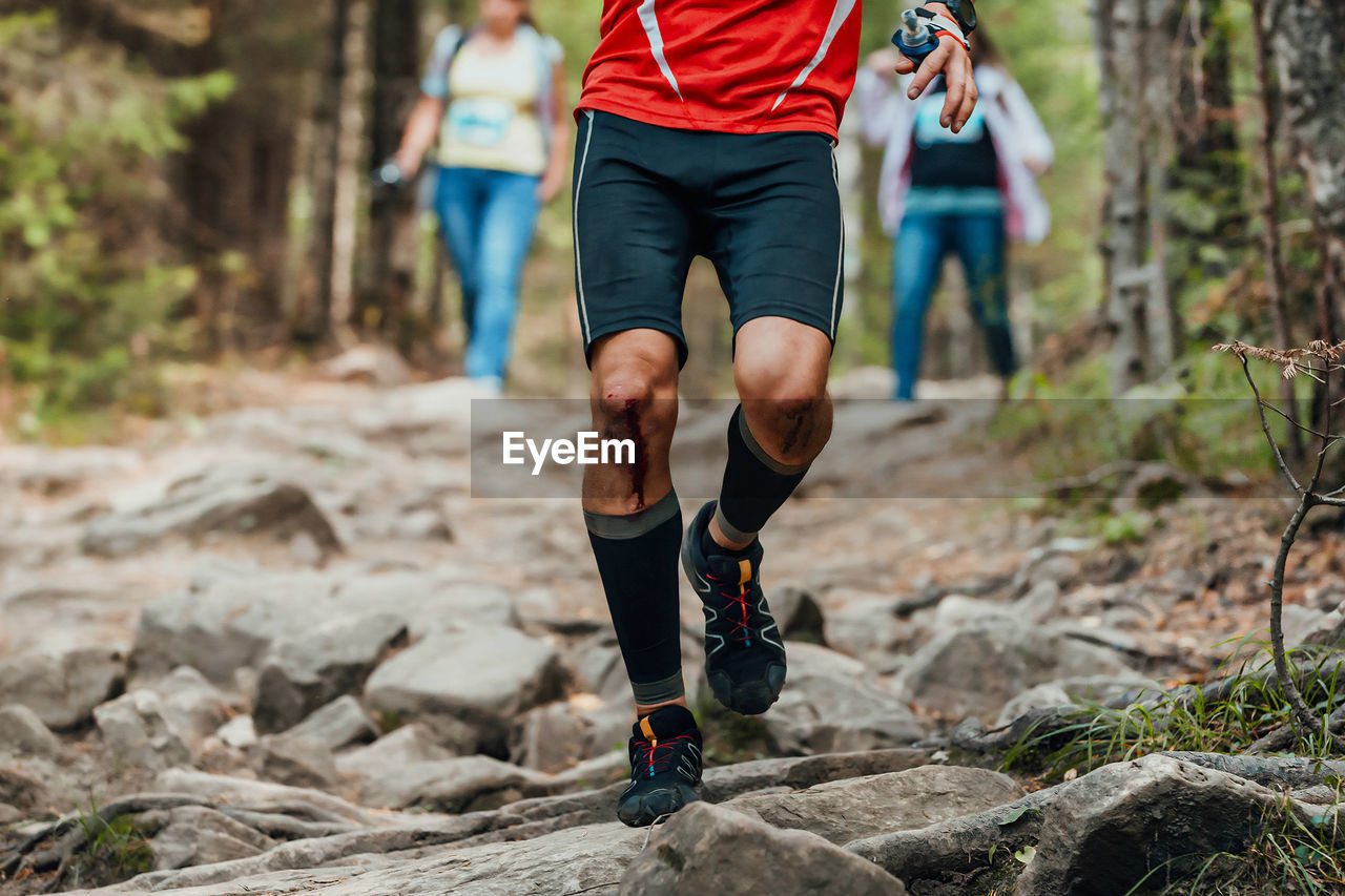 low section of woman walking on rock