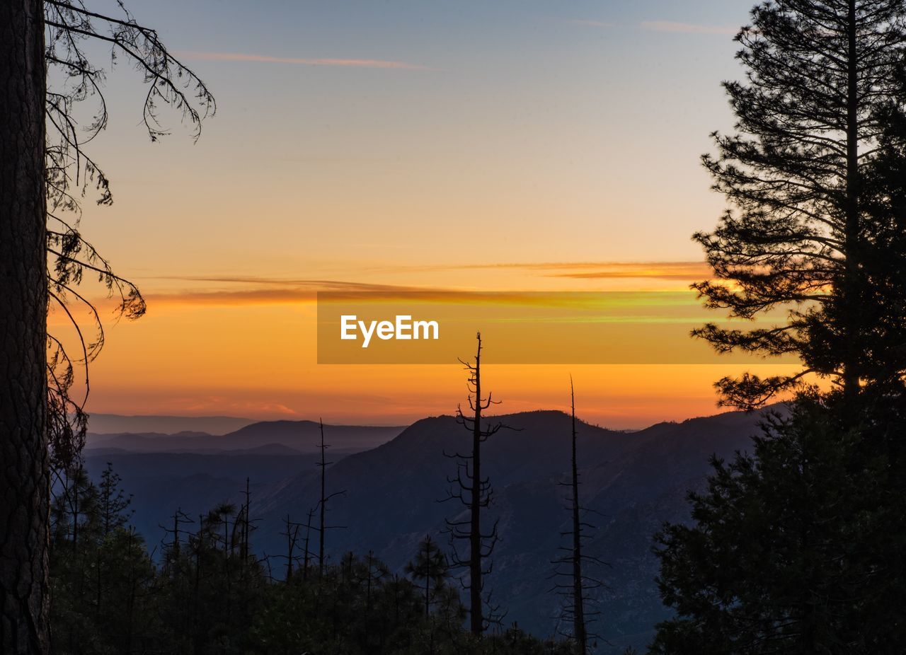 Scenic view of silhouette mountains against orange sky