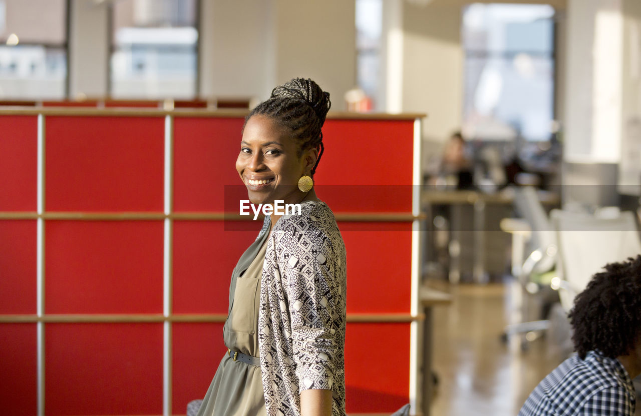 Portrait of happy businesswoman standing in office