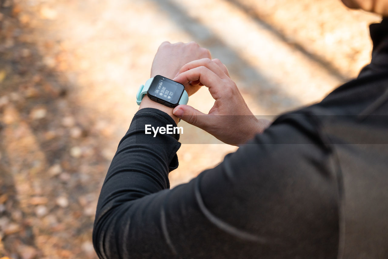 Girl checking smart watch with fitness tracker, looking at health data while exercising