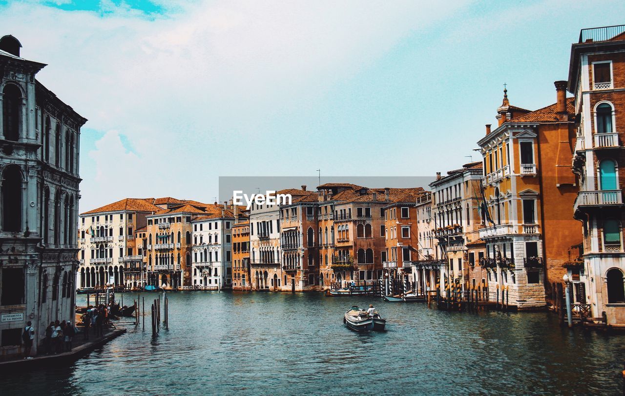 CANAL AMIDST BUILDINGS AGAINST SKY