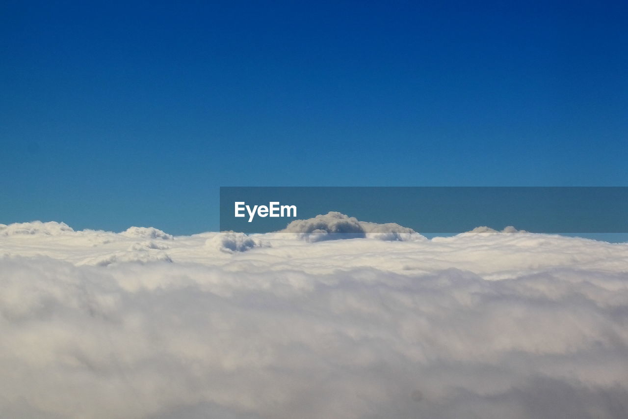 Scenic view of snowcapped mountains against blue sky