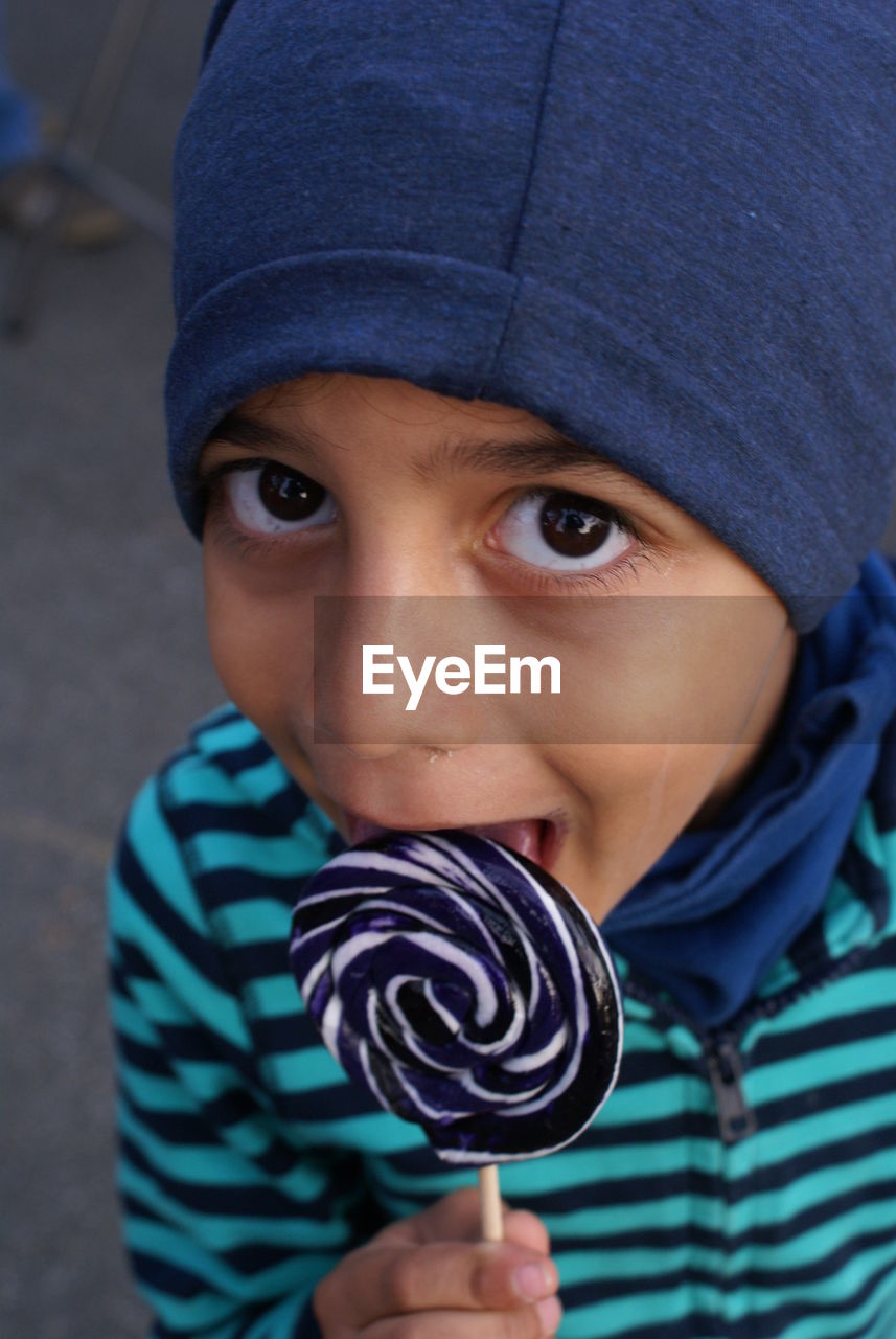 Portrait of boy licking lollipop